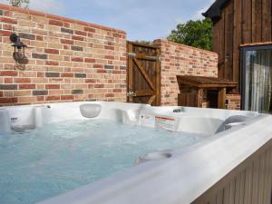 a jacuzzi tub in the backyard of a house at The Workshop in Ferndown