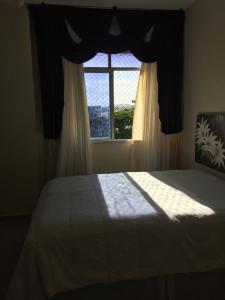 1 dormitorio con cama y ventana grande en Lindo e espacoso apartamento - Aracaju, en Aracaju