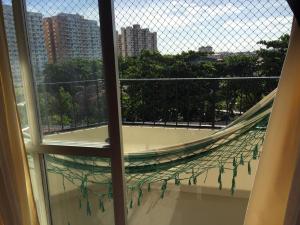 a window view of a balcony with a net at Lindo e espacoso apartamento - Aracaju in Aracaju