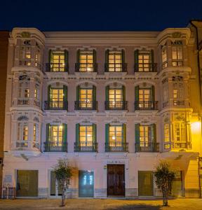 duży biały budynek z oknami w nocy w obiekcie Elegante 3 dormitorios en Centro Historico Málaga w Maladze