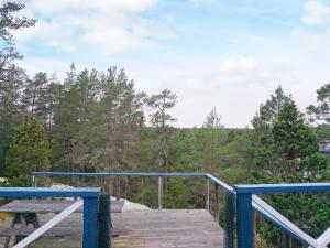een houten promenade met een picknicktafel op de top van een bos bij 7 person holiday home in INGAR in Hanskroka