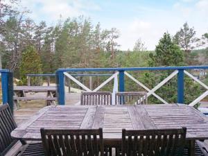 een houten tafel met stoelen op een terras bij 7 person holiday home in INGAR in Hanskroka