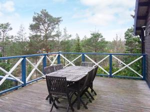 een houten tafel en twee stoelen op een terras bij 7 person holiday home in INGAR in Hanskroka