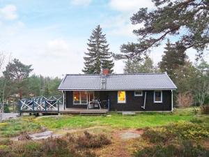 een zwart tiny house in een veld met een brug bij 7 person holiday home in INGAR in Hanskroka