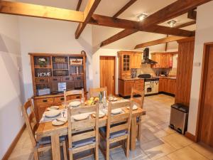 a dining room with a table and chairs in a kitchen at Barn Cottage in Alford