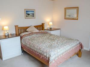 a bedroom with a bed with two night stands and two lamps at Keith House in Thurso