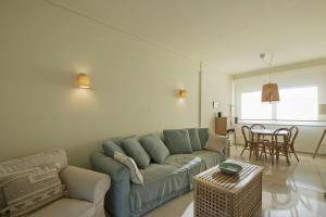 ein Wohnzimmer mit einem Sofa und einem Tisch in der Unterkunft LucyZen in Athen