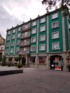 a large green building with windows on a street at Hotel Marques Del Valle in Oaxaca City