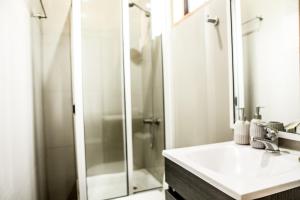y baño con ducha, lavabo y espejo. en Cabaña para dos personas en Punta de Lobos PUERTO LA MAR, en Pichilemu