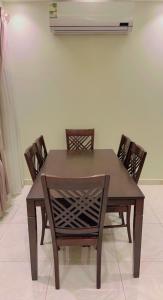 a dining room table with chairs and a fan at Ghima Jeddah in Jeddah