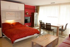 a bedroom with a red bed and a table at Haus Poseidon - Wohnung 1 1 in Wangerooge