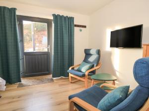 a living room with two chairs and a television at Struthan in Valtos