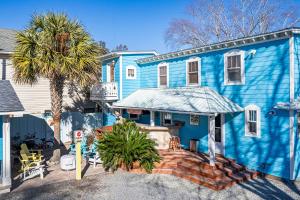 una casa blu con una palma di fronte di Island Guesthouse and Motel OBX a Manteo