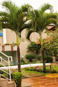 two palm trees in front of a building at Pousada No Meio do Mundo in Anchieta
