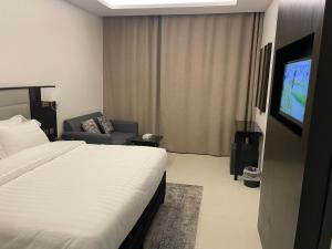 a hotel room with a bed and a television at أجنحة الطائف - اقتصادي in Taif