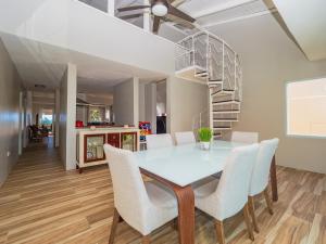 a dining room with a table and chairs and a spiral staircase at Newly Renovated 8 Bedroom Ocean Front Villa with Pool in Rio Grande