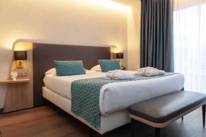 een hotelkamer met een groot bed met blauwe kussens bij Relais Saint Jacques - Châteauroux in Déols