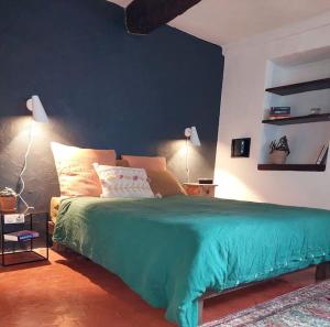 - une chambre avec un lit vert et un mur bleu dans l'établissement Maison de village Haut-de-Cagnes avec vue mer, à Cagnes-sur-Mer