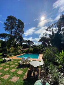 uma piscina com mesa e cadeiras num quintal em Pousada das Brumas em Brumadinho