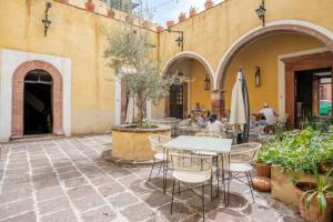 a patio with a table and chairs and an umbrella at Amapola Loft in San Miguel de Allende