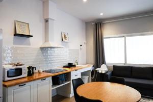 een keuken en een woonkamer met een magnetron en een tafel bij Playa Apartment in Valencia