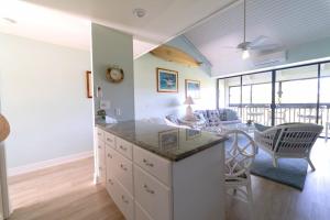 a kitchen and living room with a counter and chairs at NorthShore Haven Condo in Kahuku