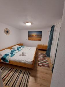 um quarto com uma cama e um quadro na parede em Casuta De Sub Munte Cârțișoara em Cartisoara