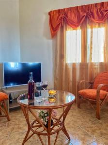 Sala de estar con mesa y 2 copas de vino en Stratos, en Lagolíon