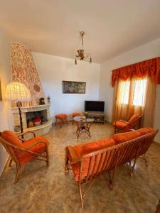 sala de estar con sofá, sillas y chimenea en Stratos, en Lagolíon