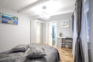 Habitación blanca con cama y escritorio en Nannie Apartaments Skenges en Rădăuţi