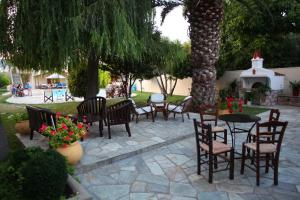 a patio area with tables, chairs, and tables at Sun Accommodation in Skopelos Town