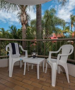 two white chairs and a table on a patio at Enderley Gardens Resort in Gold Coast