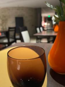 un verre de vin assis sur une table à côté d'un vase dans l'établissement Au Coeur Des Bulles, à Loches-sur-Ource