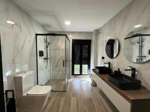 a bathroom with a shower and a toilet and a sink at La Mini Casa in Córdoba