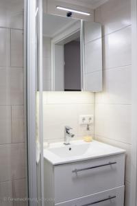 a white bathroom with a sink and a mirror at Ferienwohnung Schröder in Barntrup