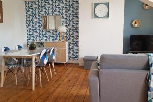 salon ze stołem i kanapą w obiekcie Appartement lumineux et moderne w mieście Le Mans