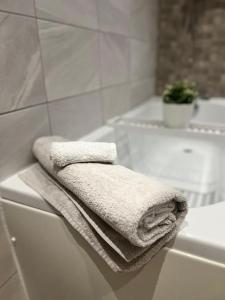 una toalla blanca sentada al lado de una bañera en HU1 Hull City Centre Modern Apartment WIFI BATH H9, en Hull