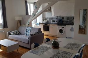 salon z kanapą i stołem w obiekcie Appartement lumineux et moderne w mieście Le Mans