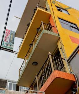 a yellow building with a balcony on the side of it at Hotel Carnaval in Huejotzingo