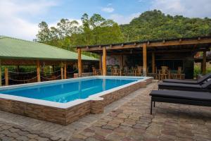 een zwembad in een patio met stoelen en een huis bij Hacienda La Huerta Puerto Plata, 2 BDR 