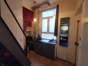 a kitchen with a sink and a washing machine at Charmant studio fonctionnel in Paris