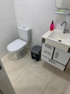 La salle de bains est pourvue de toilettes et d'un lavabo. dans l'établissement Apartamento novo Vila Guilhermina, à Praia Grande