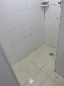 La salle de bains est pourvue d'une douche avec une porte en verre. dans l'établissement Apartamento novo Vila Guilhermina, à Praia Grande