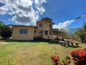 a house with a picnic table in the yard at La Cima del Cielo in Las Lajas
