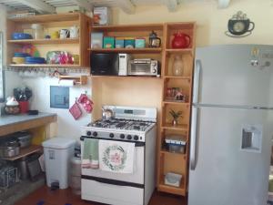 a kitchen with a stove and a refrigerator at La Cima del Cielo in Las Lajas