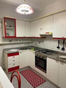 una cucina con mobili bianchi e un forno a piano cottura di Appartamento in Santa Caterina a Siena Altre 6 foto