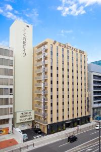 a large building with a sign on the side of it at Kuretake Inn Premium Shizuoka Ekimae in Shizuoka