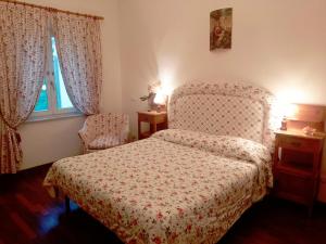 sypialnia z łóżkiem, krzesłem i oknem w obiekcie Il Campanile II Locazione Turistica w Pizie