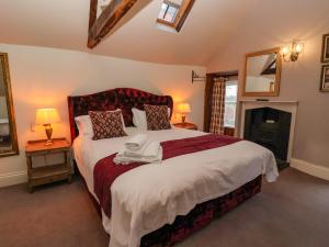 ein Schlafzimmer mit einem großen Bett und einem Kamin in der Unterkunft Manor House in York