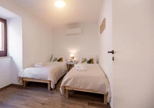 two beds in a room with white walls at Centro storico Sciacca - Casa Di Pisa in Sciacca +45 photos